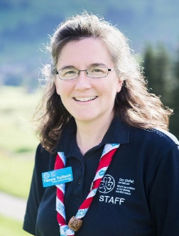 Our Chalet Staff Family Member in uniform with mountains in background