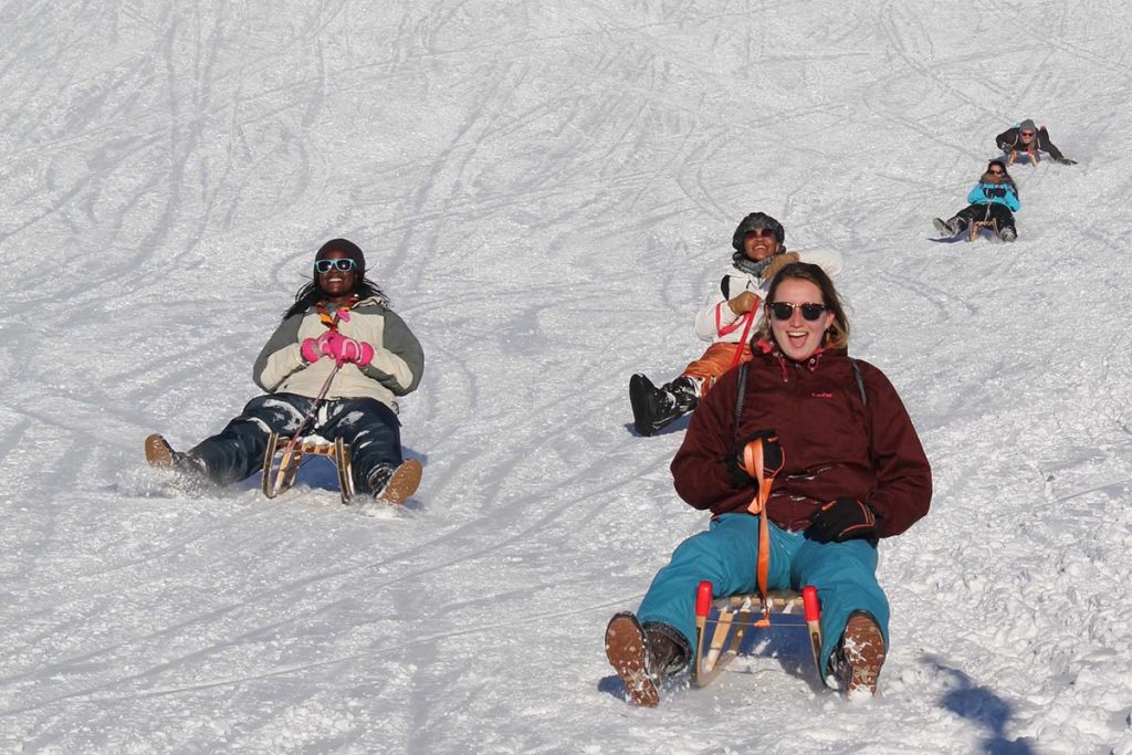 young women sledging and laughing