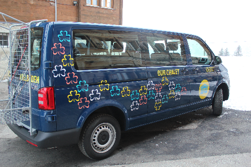 Dark blue van with WAGGGS trefoils and other Our Chalet branding