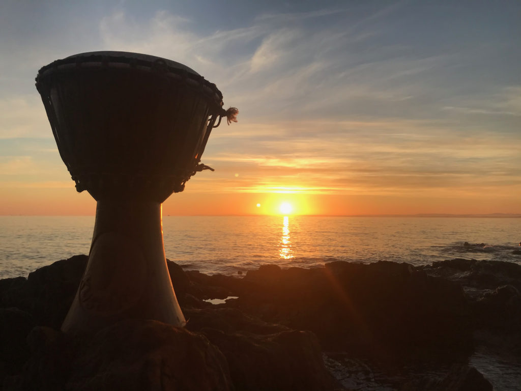 African drum by the sea at sunset